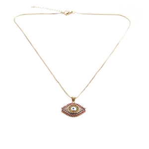 Close-up of golden evil eye pendant with vibrant red, black, and blue zircons