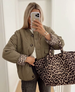 Detailaufnahme der Steppjacke mit Leopardenmuster-Futter und passender Tragetasche