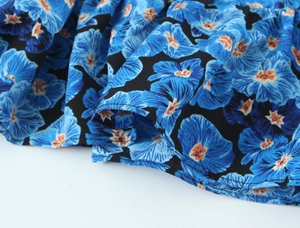 Detailaufnahme des floralen Tintendrucks auf schwarzem Chiffon mit Lagenoptik