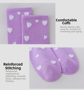 Detail of purple cotton socks with white hearts, showing elastic cuffs and flat toe seams