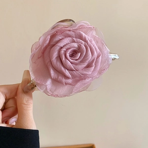 Detaillierte Nahaufnahme der geschichteten rosa Organzablüten auf einer Haarklammer für Damen