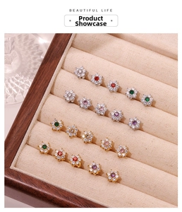 Macro shot of colorful zircon flower stud earrings in gold and silver plating on velvet