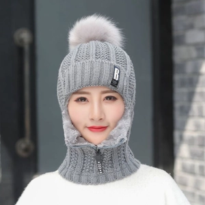 Gros plan sur bonnet tricoté gris avec doublure polaire, pompon et cache-col à fermeture