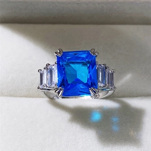 Macro shot of rectangular aquamarine zircon ring with side diamonds on silver band