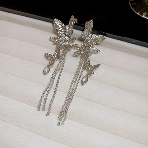 Detailed close-up of silver butterfly tassel earrings with teardrop gemstones