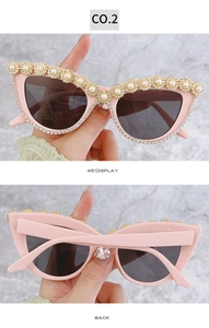 Occhiali da sole cat-eye rosa con fiori dorati, perle e strass in dettaglio