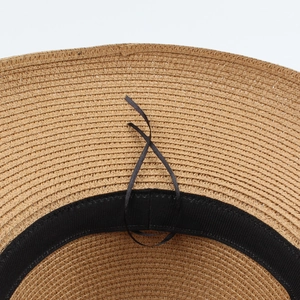 Close-up of woven straw hat interior with adjustable drawstring and black sweatband