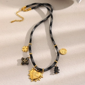 Vue détaillée du collier en corde tressée avec trèfle en or 18 carats et cœurs