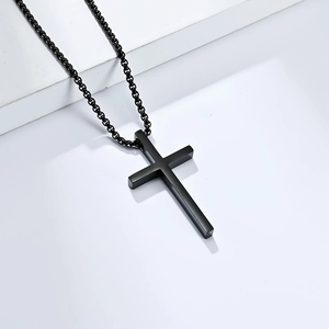 Minimalist black stainless steel cross necklace for men on a clean studio background