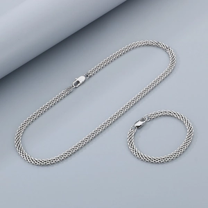 Détail macro d'un ensemble collier et bracelet en acier inoxydable tressé argent 6 mm