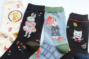 Detailed close-up of colorful socks featuring embroidered poodle, rabbit, and cat patterns