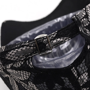 Detail view of the silver metal buckle and lace strap on a black baseball cap