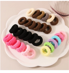 Close-up of colorful elastic hair ties in a flower-shaped bowl, high elasticity bands
