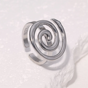 Minimalist spiral silver stainless steel open ring on white textured stone surface