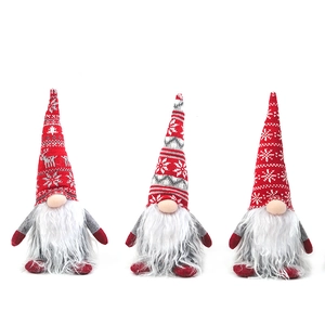 Trois gnomes de Noël avec bonnets en tricot rouge et motifs de flocons sur fond blanc