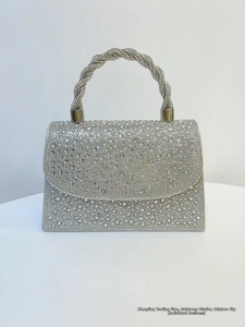Macro shot of silver rhinestone evening bag with braided handle and sparkly crystal finish