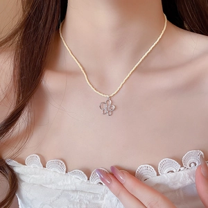 Dettaglio della collana di perle di cristallo giallo con ciondolo a fiore in zircone