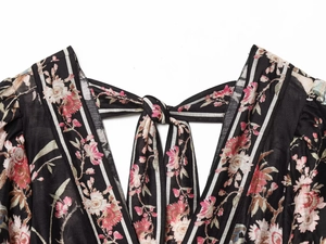 Detail of floral print dress with pink blossoms and striped tie-neck collar design