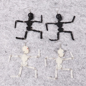 Detail of jointed resin skeleton earrings with moving parts and metal hook in two colors