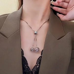 Collier réglable en acier titane avec sphères creuses en zircon porté par un mannequin