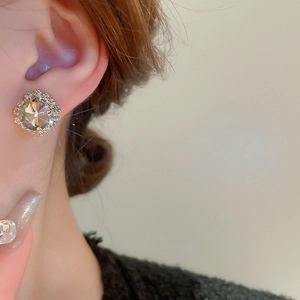Nahaufnahme eleganter champagnerfarbener Kristall-Ohrstecker mit Strassbesatz am Model