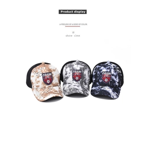 Detailed view of tie-dye baseball caps with embroidered patches and mesh backing