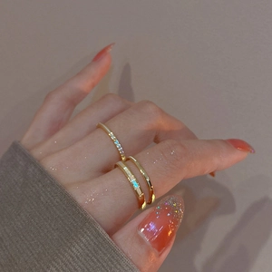 Close-up of gold double-layer open rings with zircons and shell inlay on finger