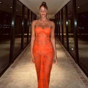Close-up of vibrant orange strapless maxi dress with sheer lace mesh and cut-out details