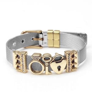 Detail of silver stainless steel mesh bracelet with gold key, ring and heart lock charms