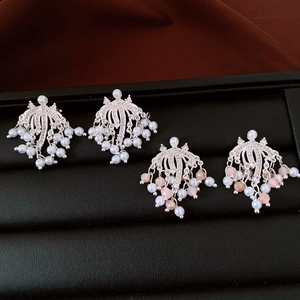 Dettaglio di orecchini a clip con nappe di perle e strass in una confezione