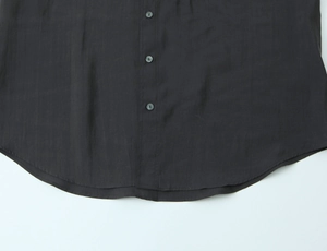 Detail of the curved hem and buttons on this charcoal poplin shirt with fine texture