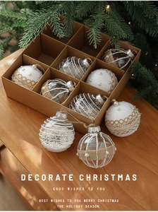 Close-up of 8cm Christmas ball ornaments with pearl and gold lace in a kraft box