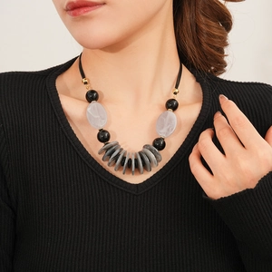 Close-up of a model wearing the leather double-layer necklace with oval resin pendants