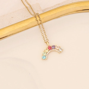Close-up of golden necklace featuring a vibrant rainbow pendant with colorful gemstones
