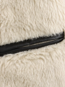 Detailed macro view showing beige faux fur texture stitched with black leather material