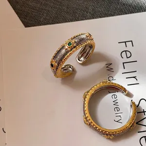 Vintage oval textured open ring with green gemstone and gold-silver dual tone plating