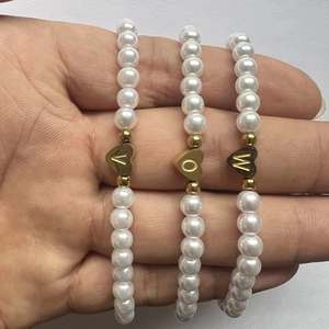 Vintage faux pearl bracelet set with three golden heart pendants featuring letters V, O, and W
