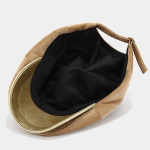 Detail of corduroy beret featuring inner lining and adjustable back strap with metal buckle