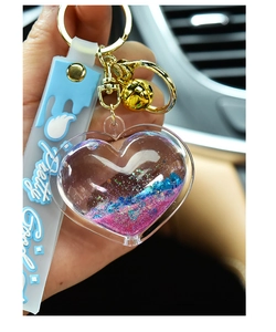 Close-up of heart-shaped liquid quicksand keychain with pink and blue flowing glitter