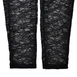 Dettaglio ravvicinato di pizzo floreale nero trasparente e trama a rete sui leggings