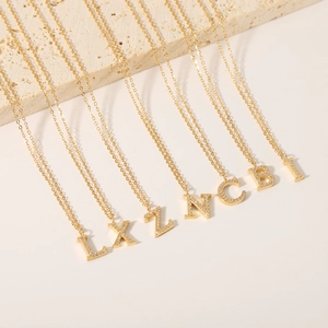 Golden titanium steel 26-letter necklaces with sparkling zircons on a stone base