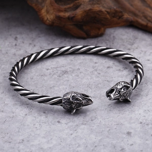 Close-up of retro stainless steel twisted cuff with detailed animal head carvings