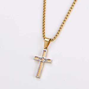 Macro view of gold and silver stainless steel cross pendant with Jesus engraving