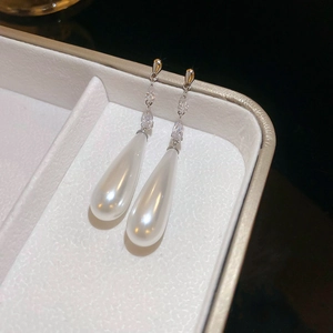 Close-up of elegant silver water-drop pearl earrings with zircon accents in a gift box