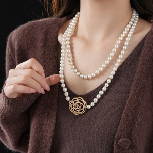 Detail of double-layer pearl necklace featuring a golden hollow rose zircon pendant