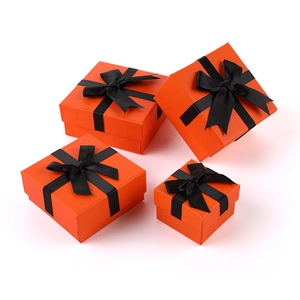 Classic orange jewelry boxes with black ribbon bows in four square sizes on white background