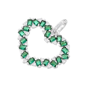 Macro detail of heart-shaped gold-plated pendant with green gems and white zircons