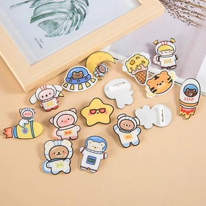 Cute acrylic astronaut animal pins with bear and pig designs on a warm background