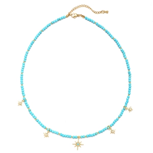 Detail view of sky blue beads and gold star pendants on a bohemian style necklace