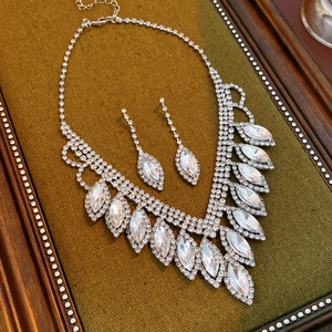 Exquisite silver necklace and earrings set with teardrop crystals on moss green velvet